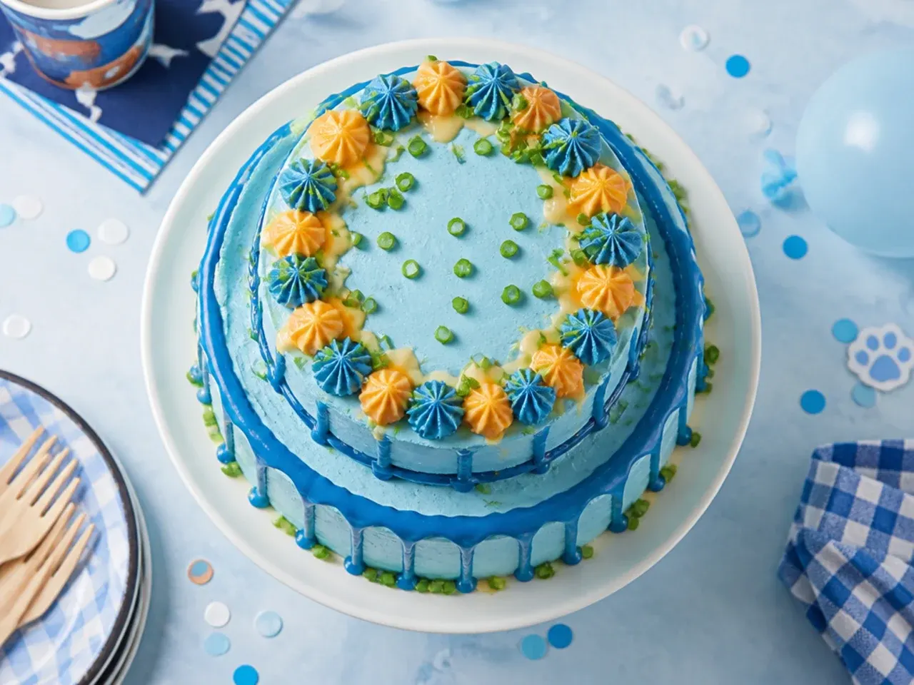 Budget two tier blue and orange buttercream cake with basic sprinkles and a simple plastic topper