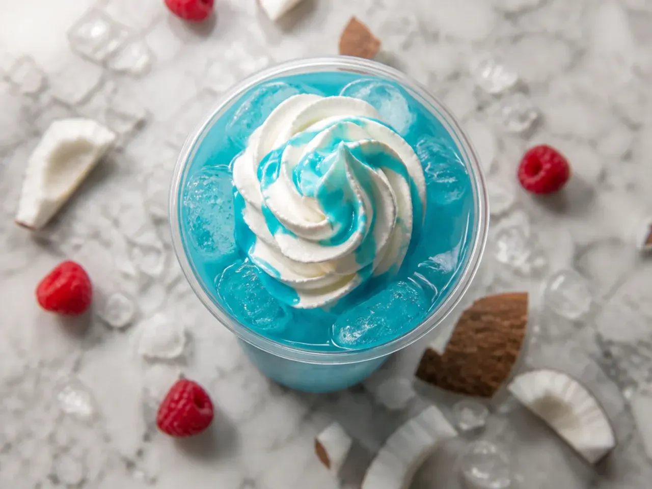 Tall glass of bright blue iced energy drink with coconut swirl and ice