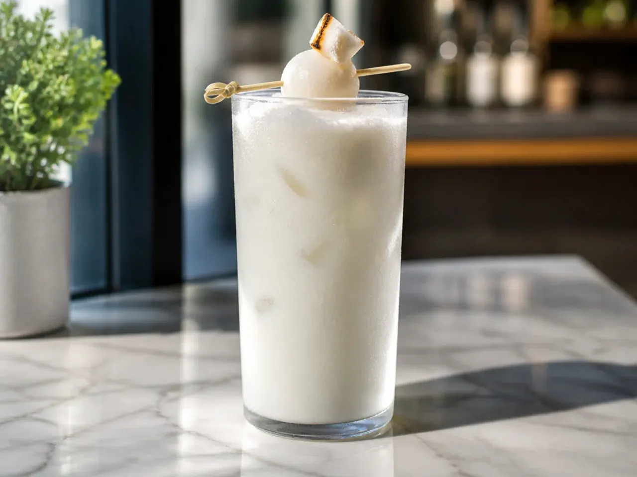 Smooth coconut cream fizz with a pale coconut cream float over sparkling syrup soda