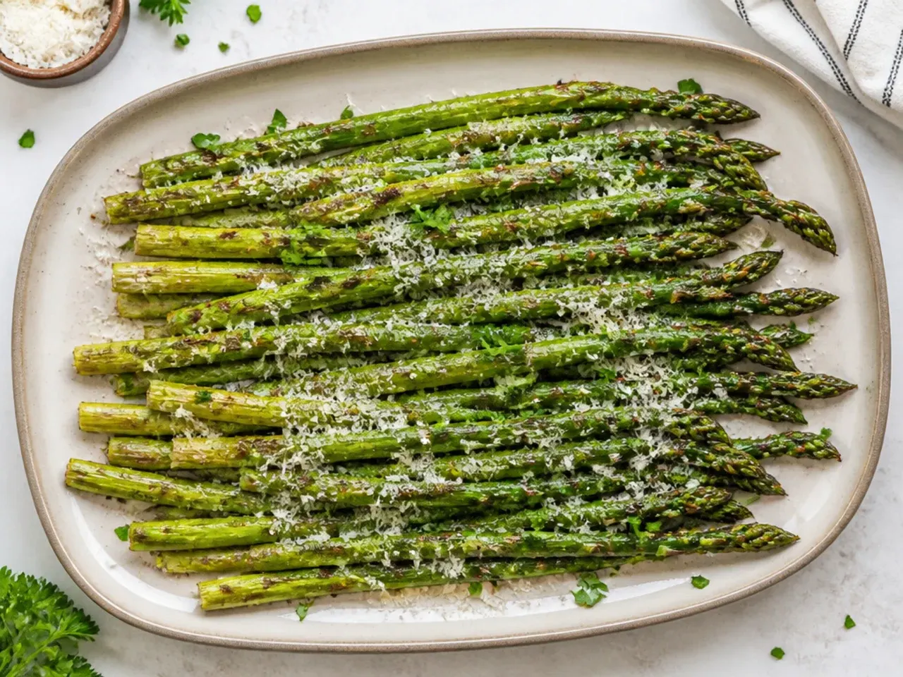 Garlic parmesan asparagus spears in an air fryer basket