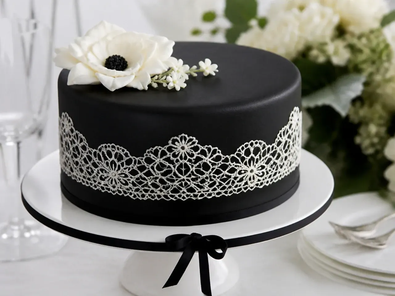 Delicate black cake design with white edible sugar lace band