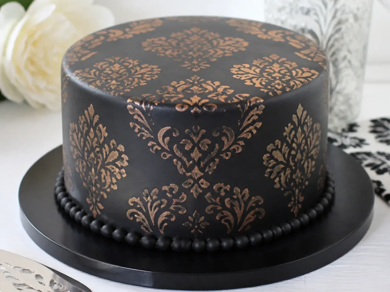 Vintage black damask stencil cake design with metallic pattern
