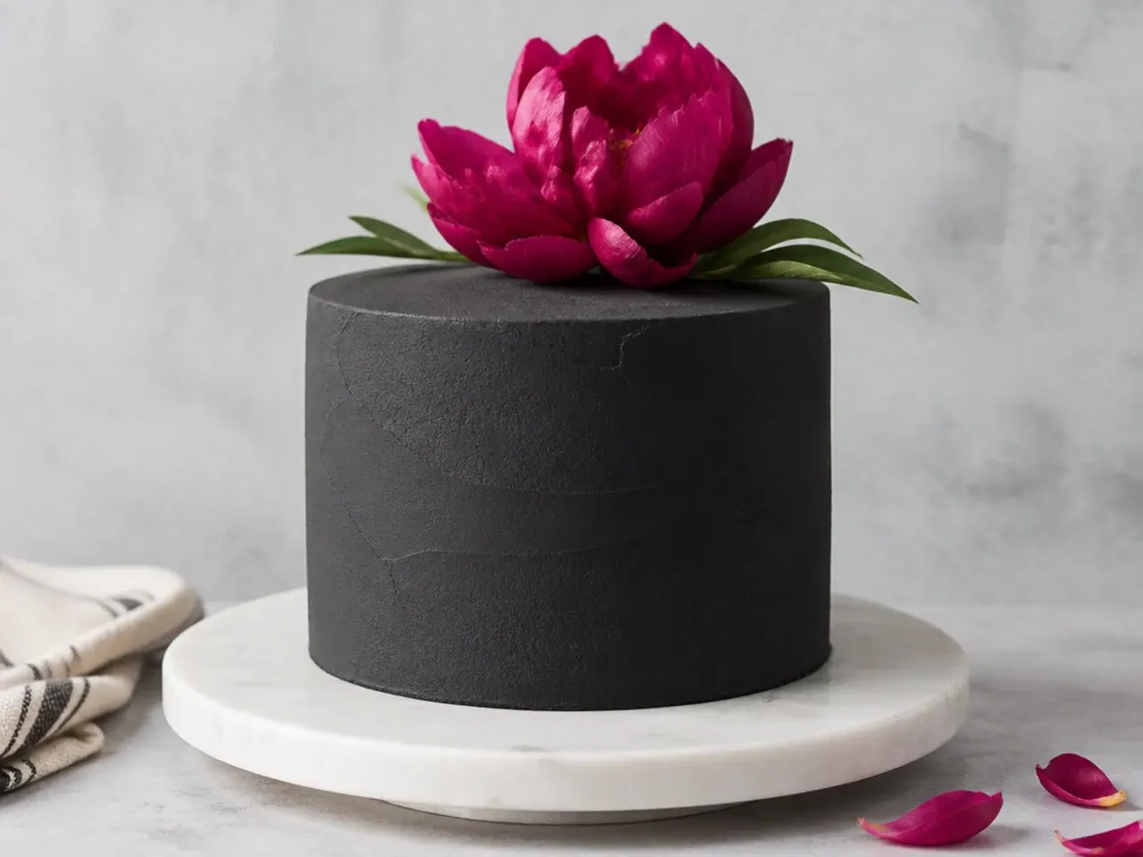 Minimal black cake design with a single statement bloom