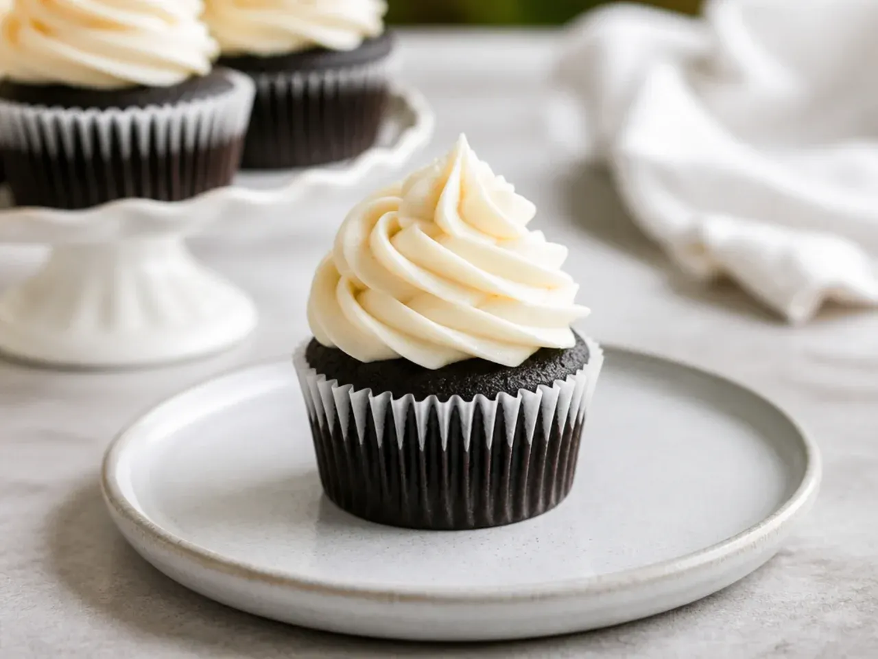 Mini black cake cupcakes with rum buttercream swirls piped with a 1M tip