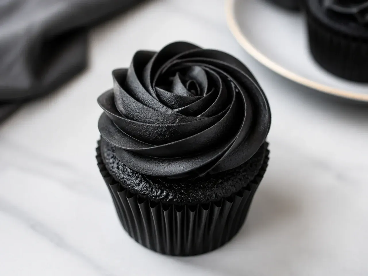 Minimal black cupcakes each topped with one clean black buttercream rosette
