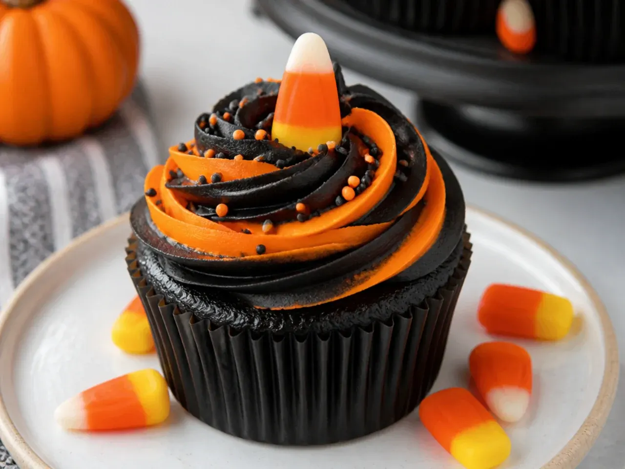 Festive black and orange swirl Halloween cupcakes with candy corn