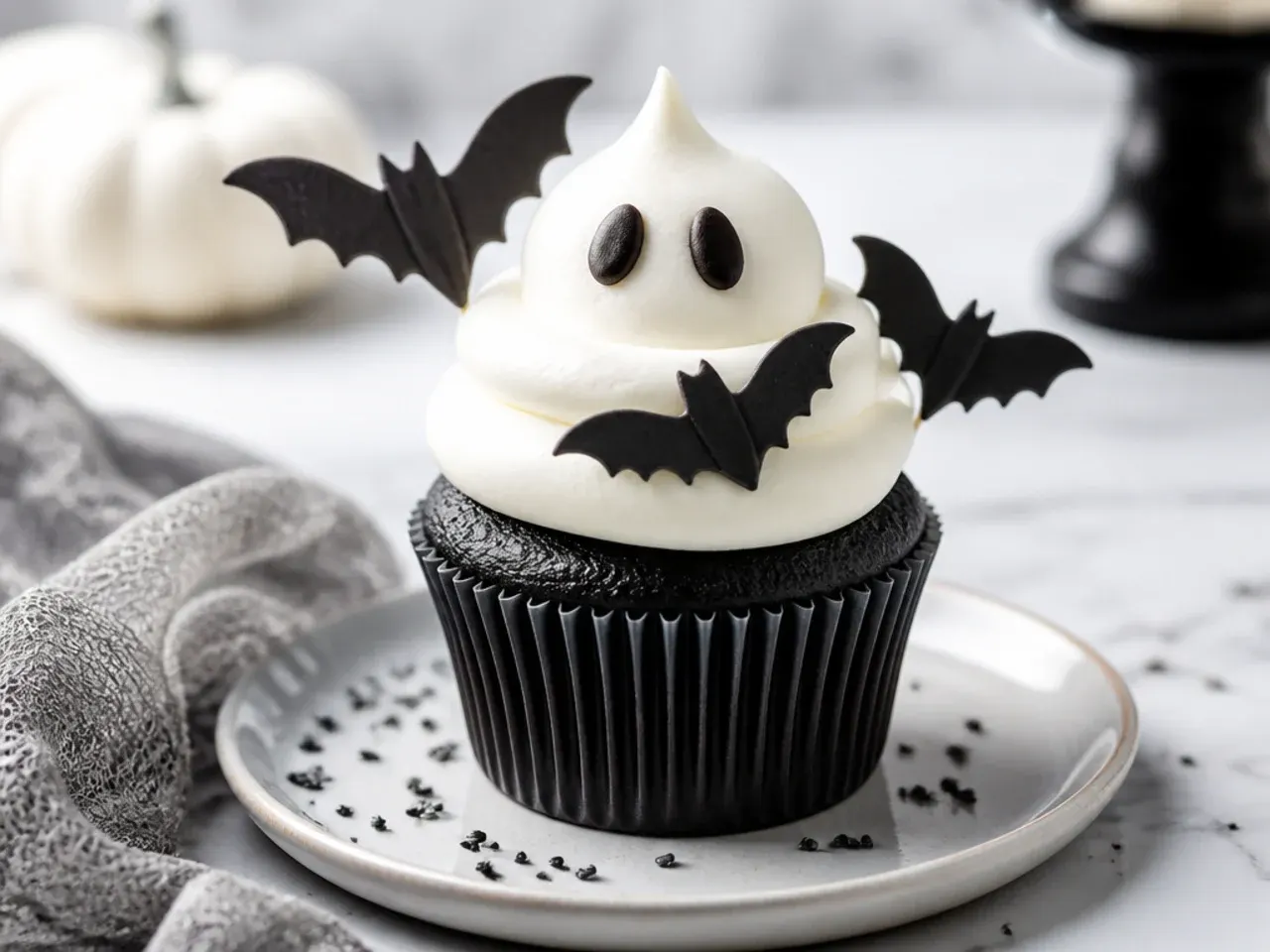 Whimsical black cupcakes with white buttercream ghosts and fondant bats