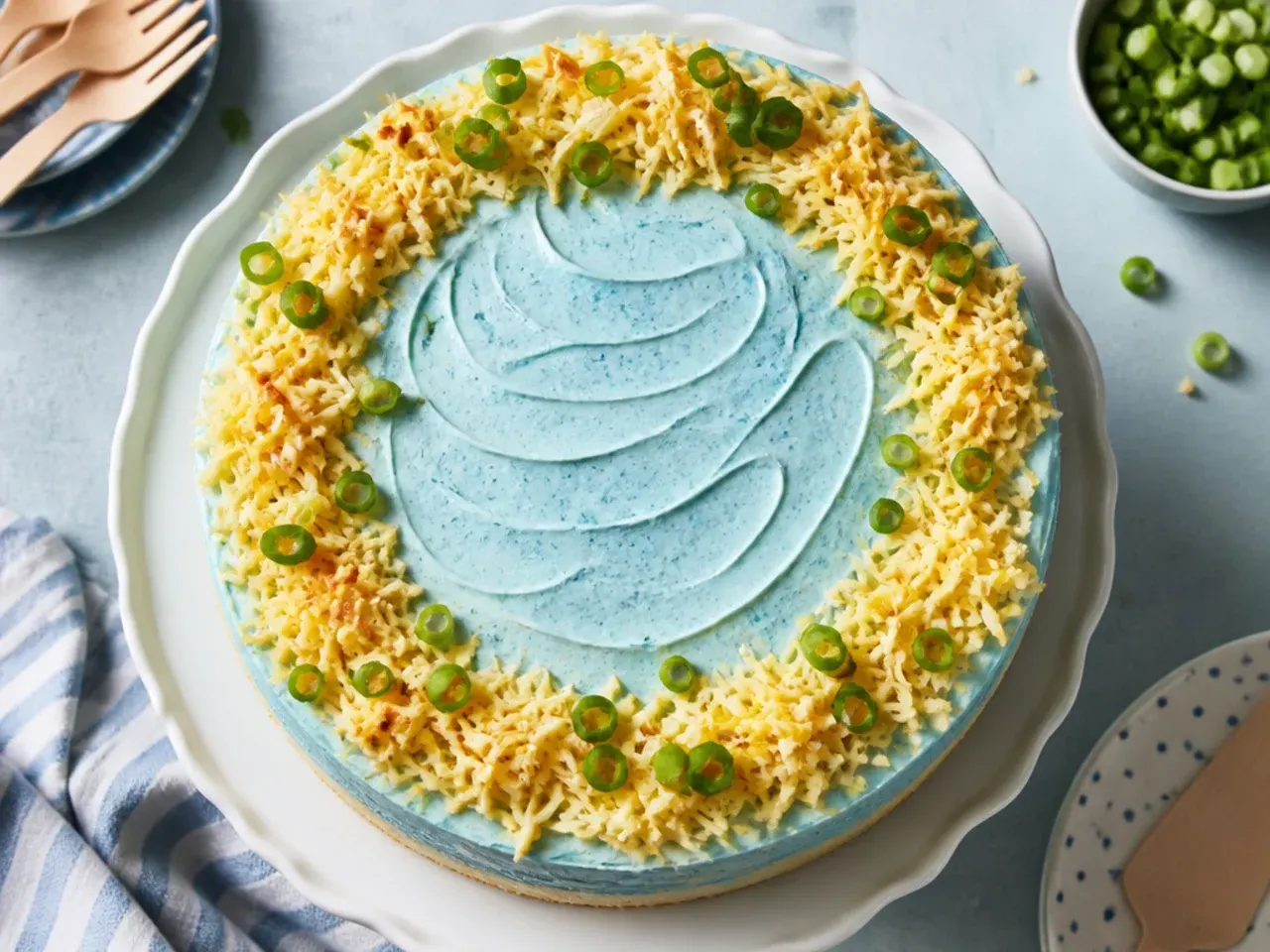 Frozen ice-cream cake with blue whipped cream frosting on a plate, sliced with clean edges