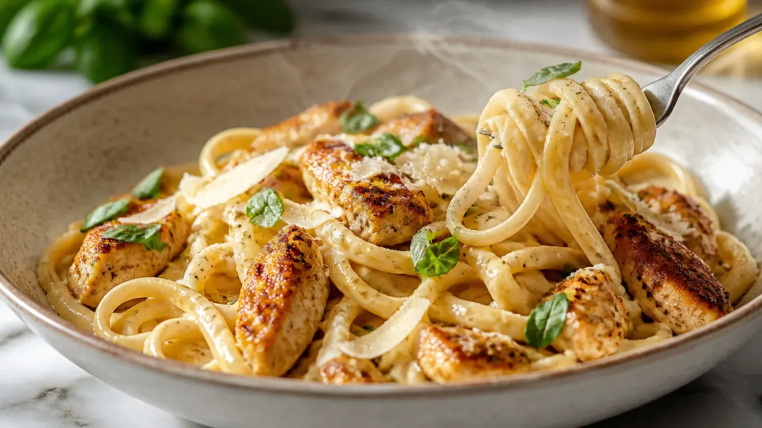 A skillet of creamy cajun chicken alfredo with fettuccine, blackened chicken strips, and a dusting of Parmesan and parsley