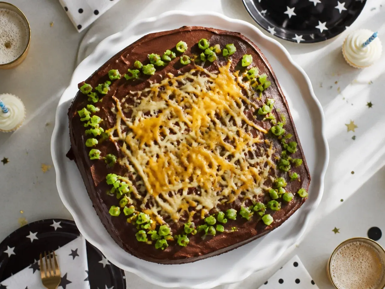 Chocolate sheet cake in a baking tin with poured icing, cut into squares