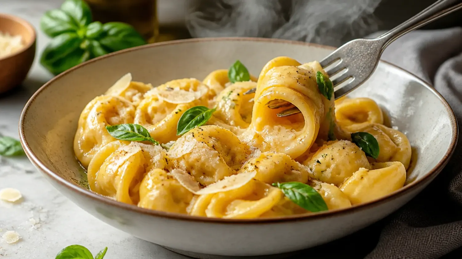 Golden, bubbling baked cheese tortellini in marinara sauce topped with melted mozzarella and fresh basil in a white baking dish