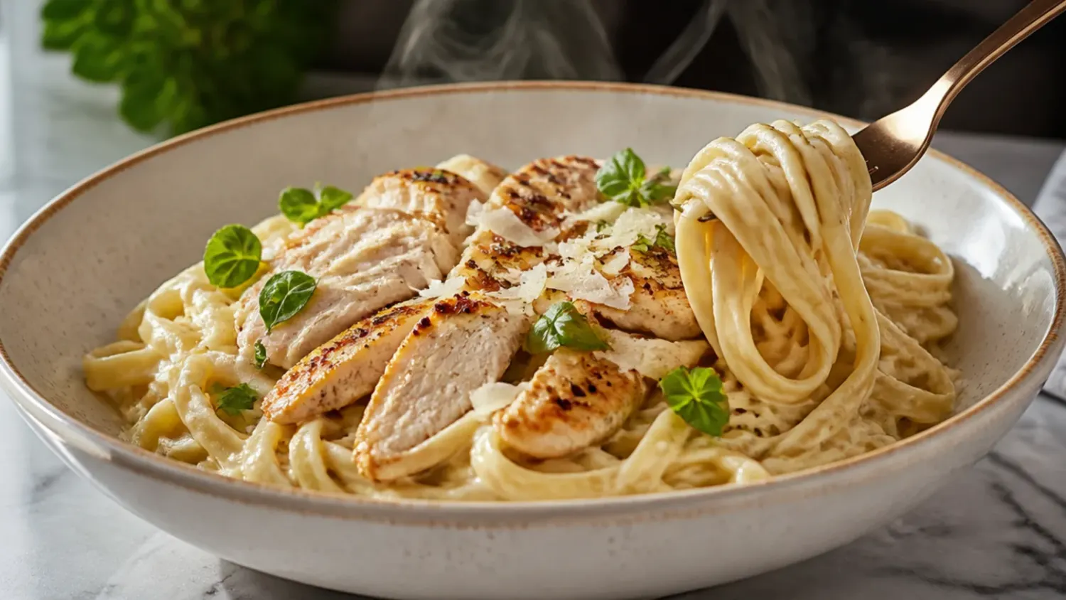 Creamy chicken alfredo pasta twirled on a fork over a bowl of fettuccine, garnished with parsley and grated Parmesan