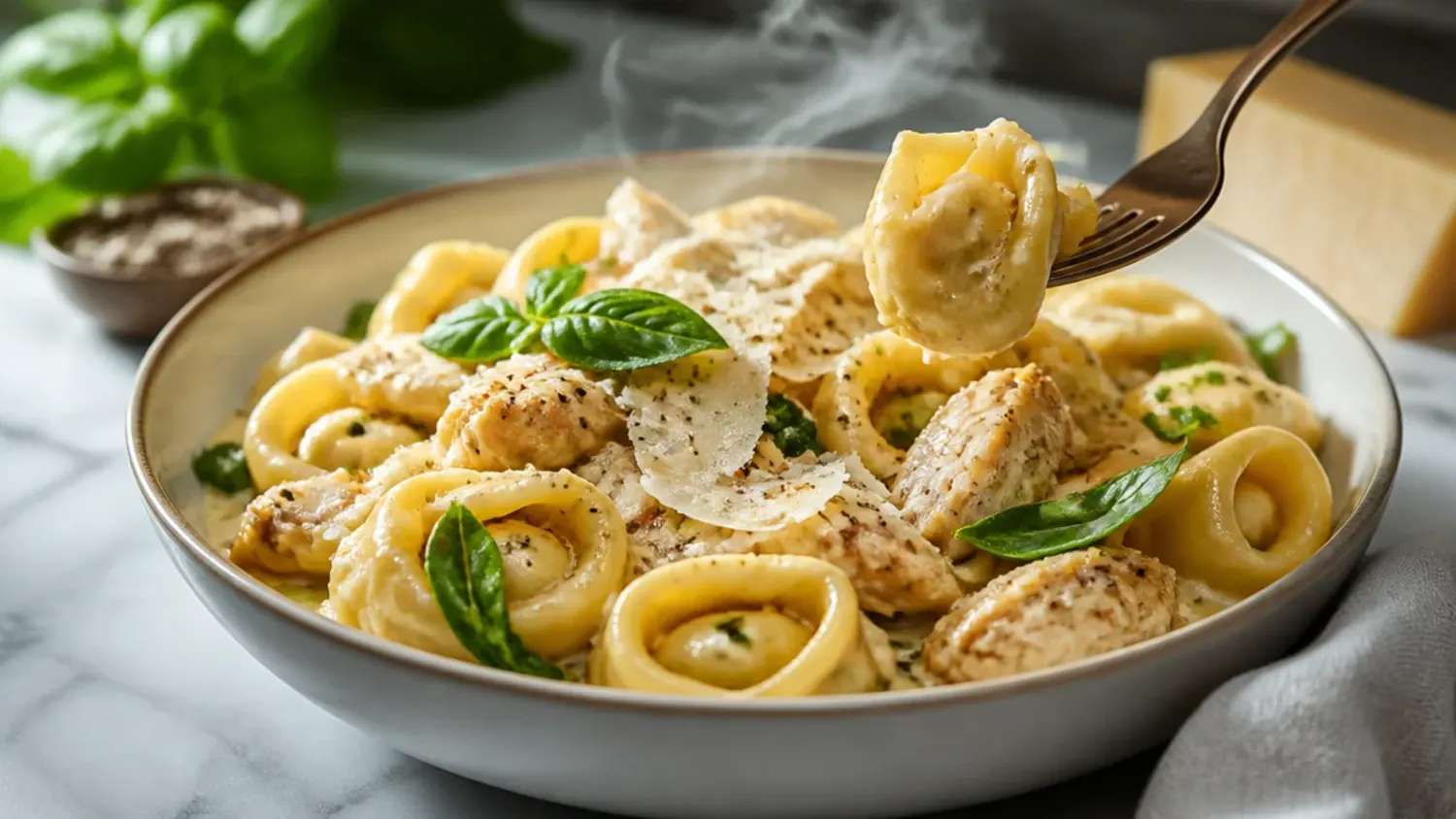 A skillet of creamy chicken tortellini with wilted spinach, sun-dried tomatoes, and grated parmesan