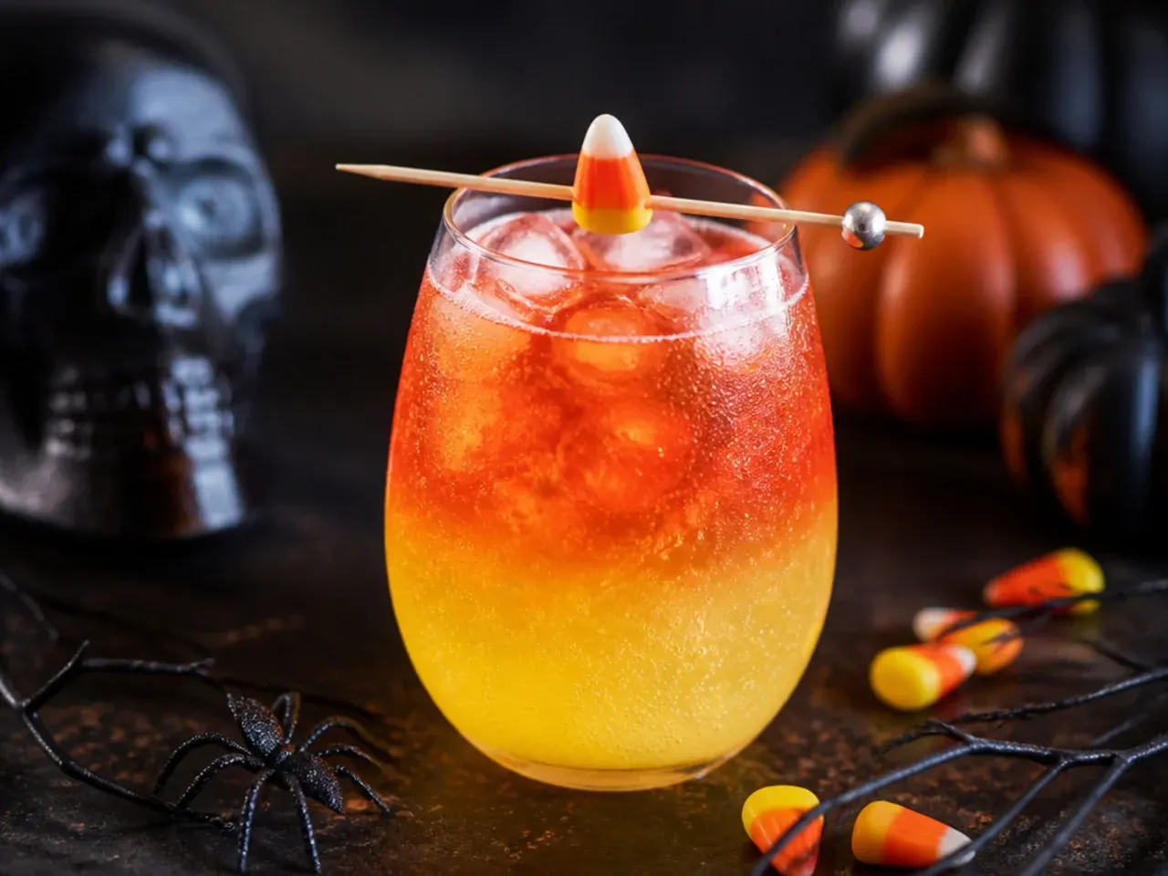 Layered orange, yellow and white candy corn sparkler drink in a clear glass