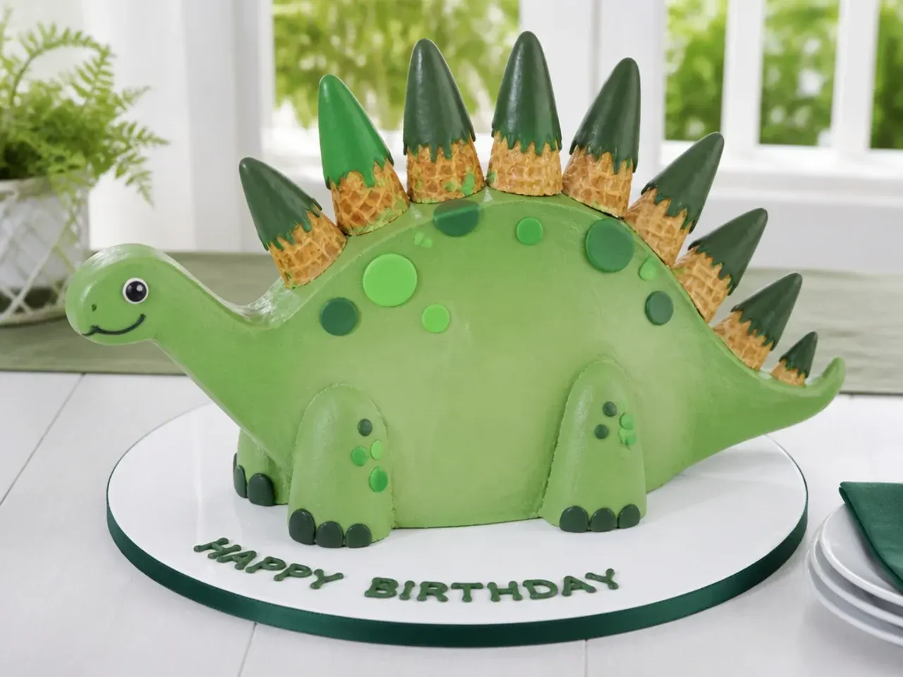 Easy stegosaurus dinosaur birthday cake with ice cream cone spikes dipped in candy melts