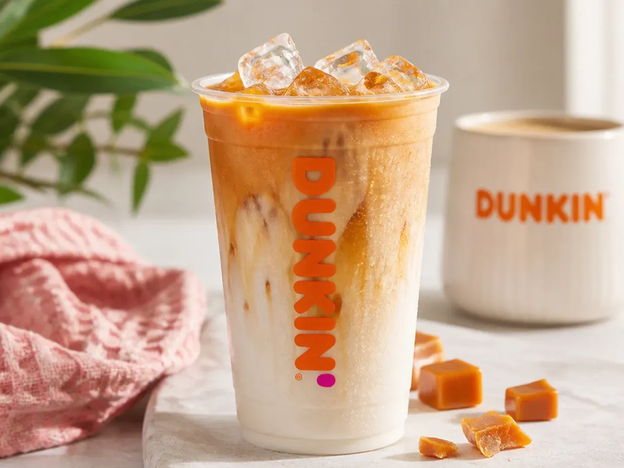 Finished copycat Dunkin drinks garnished with whipped cream, caramel drizzle and cinnamon on a tray
