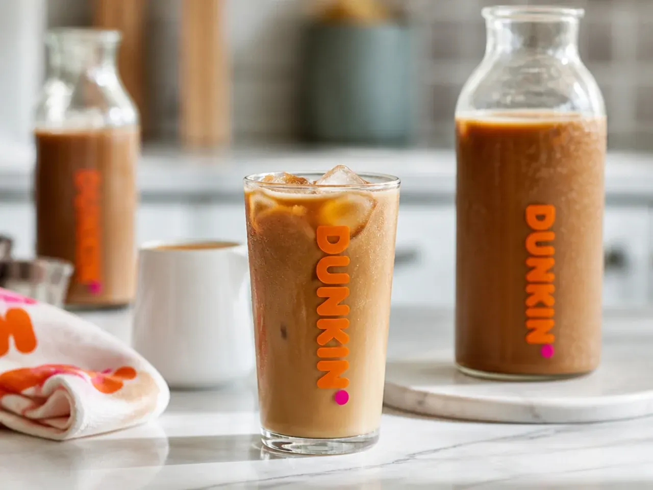 Mason jars of cold brew concentrate and syrup lined up in a fridge