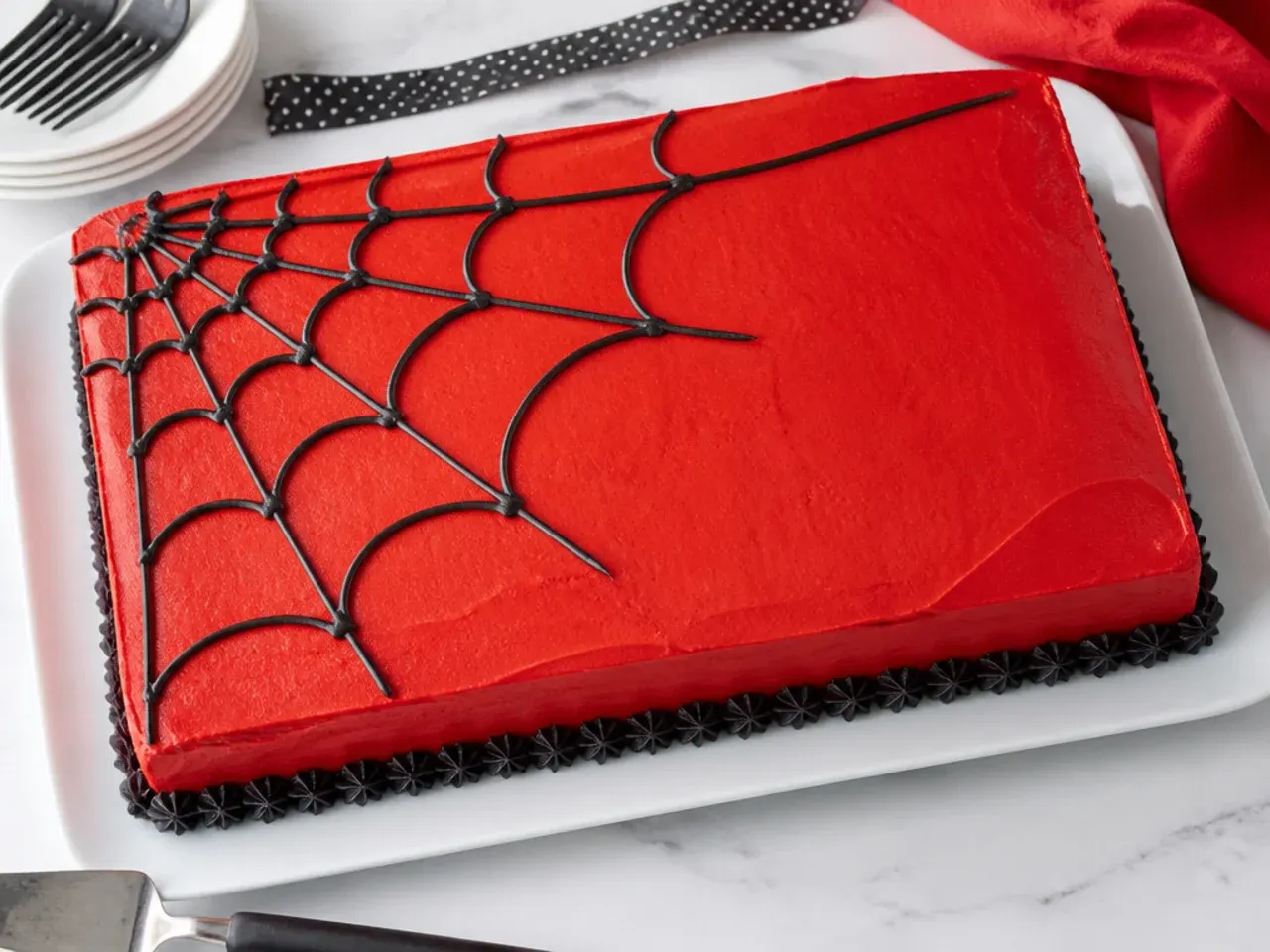 Simple Spiderman sheet cake with corner web design in black icing