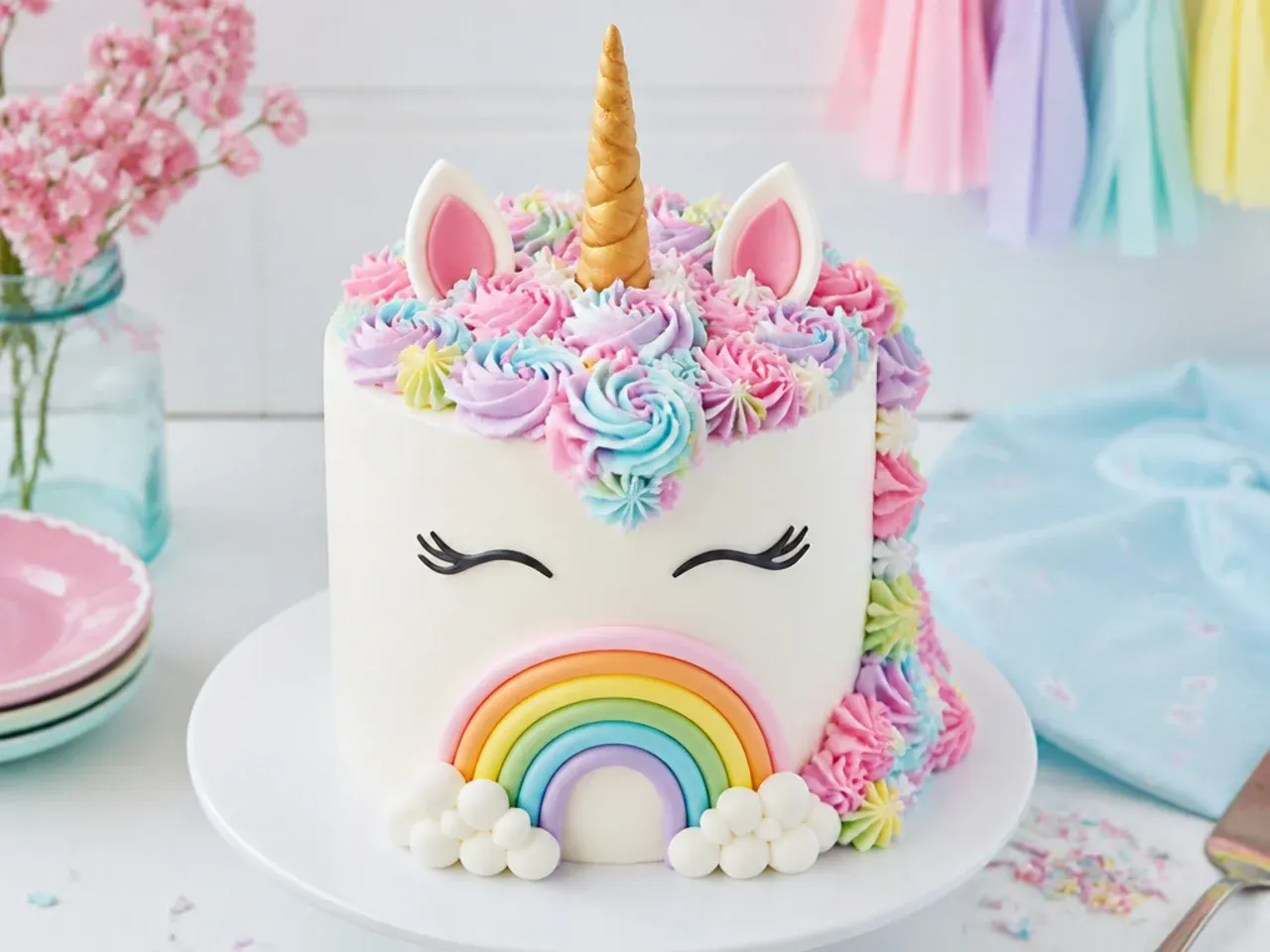 Whimsical unicorn cake with fondant rainbow, marshmallow clouds and pastel buttercream mane