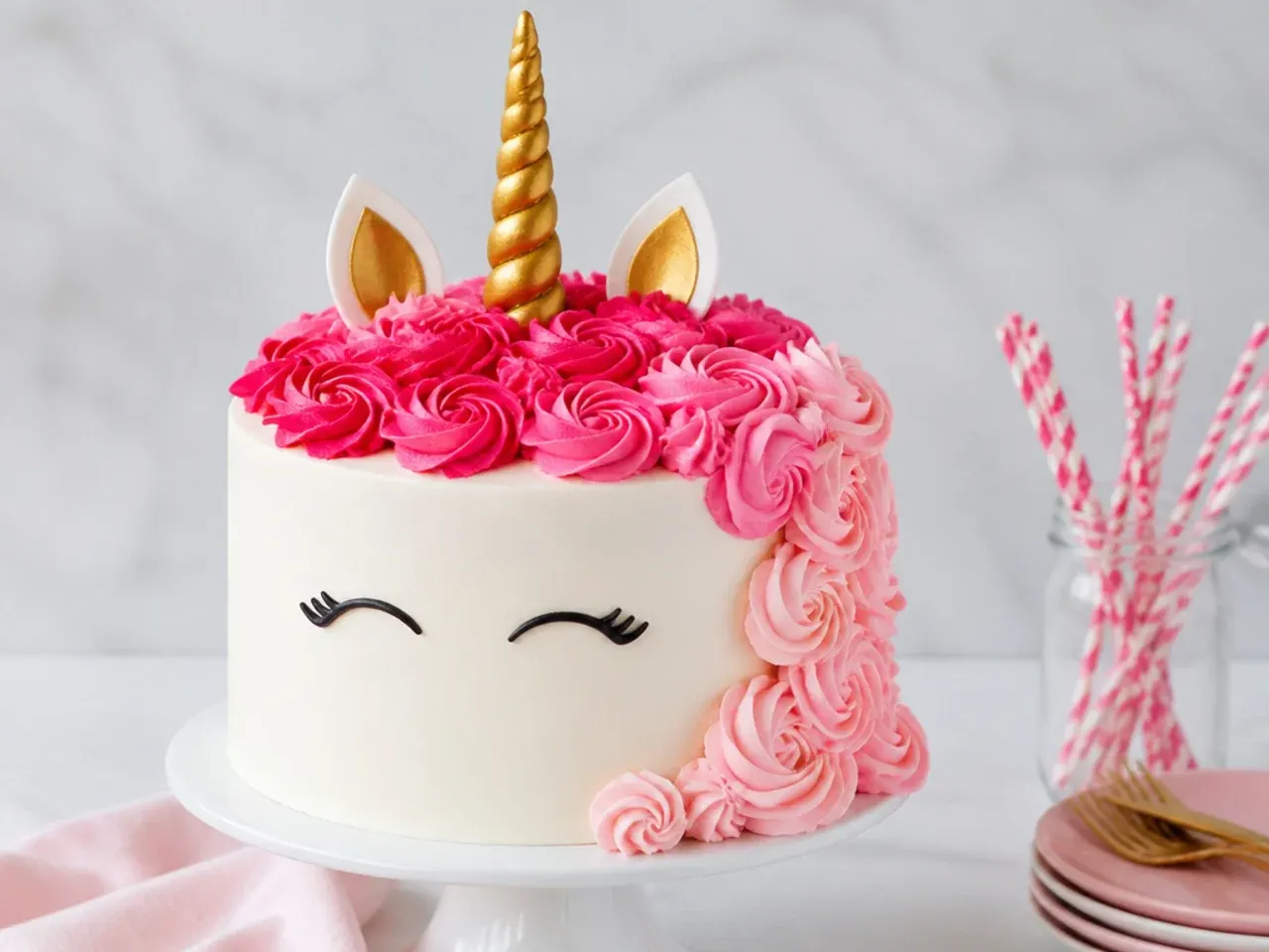 Ombre unicorn cake mane fading from deep raspberry to baby pink buttercream swirls