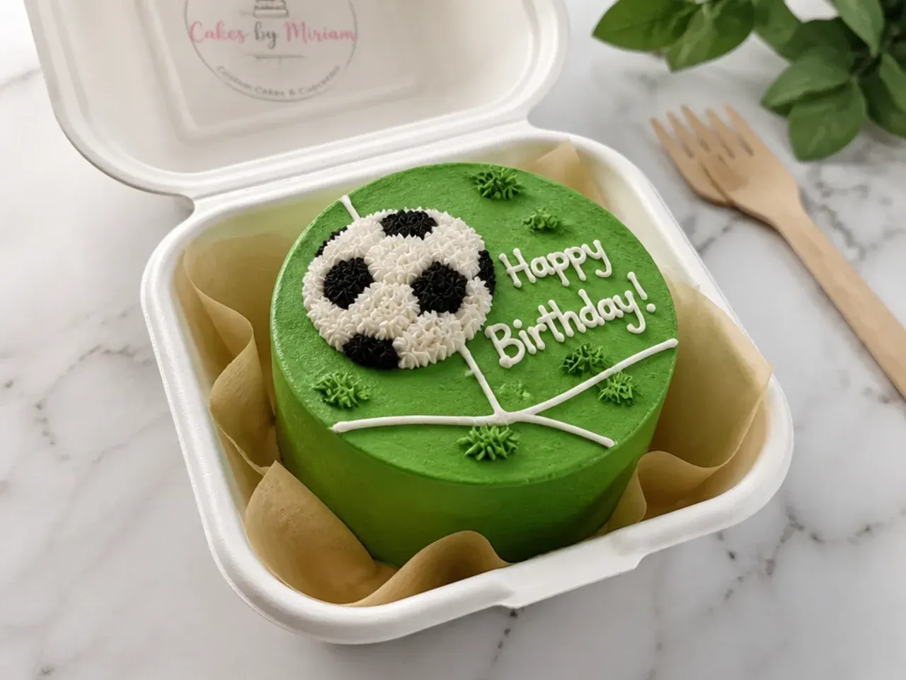 Bento mini football birthday cake in a lunchbox with hand piped ball and lettering