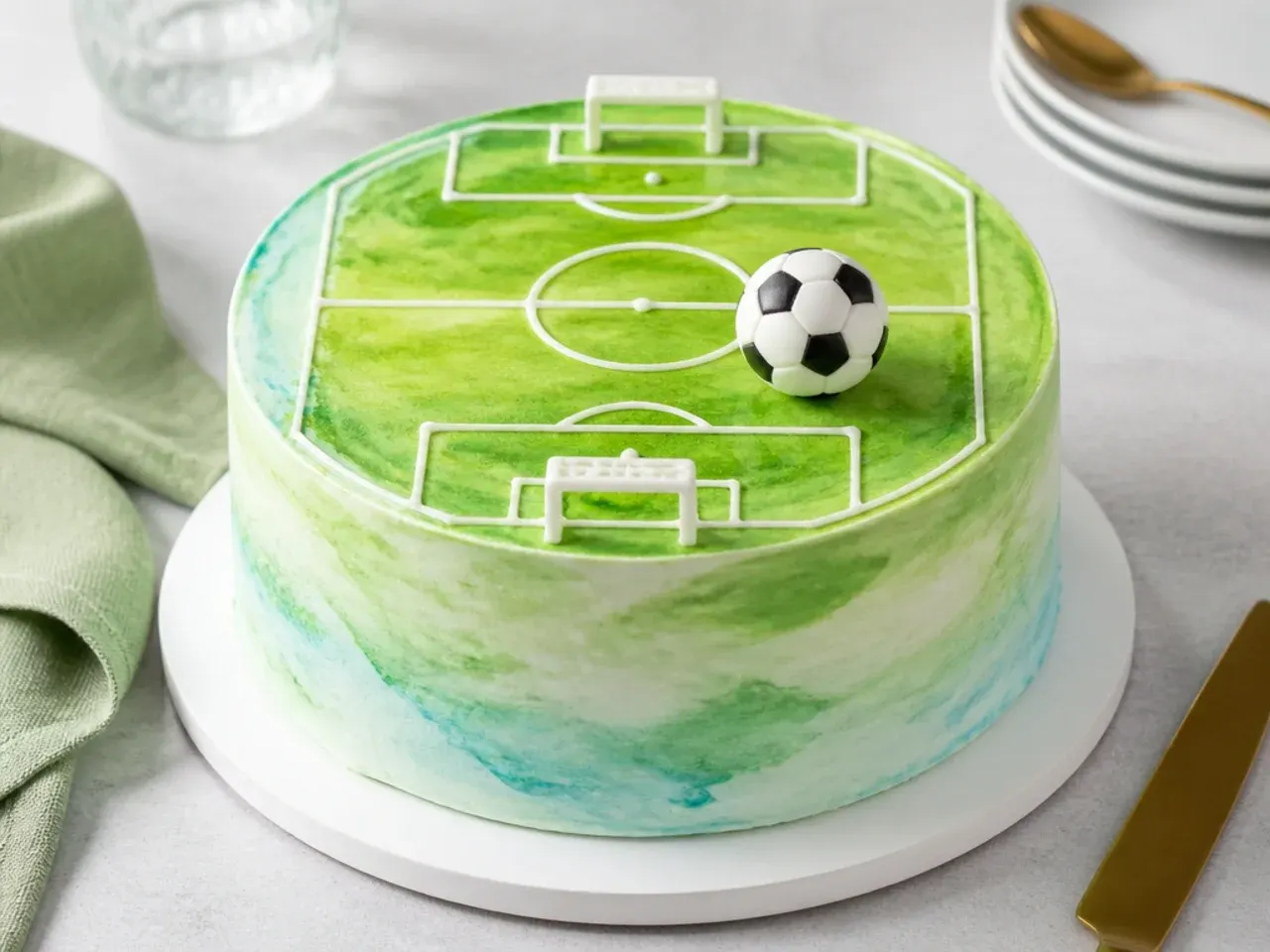 Modern watercolour pitch football cake design with piped markings