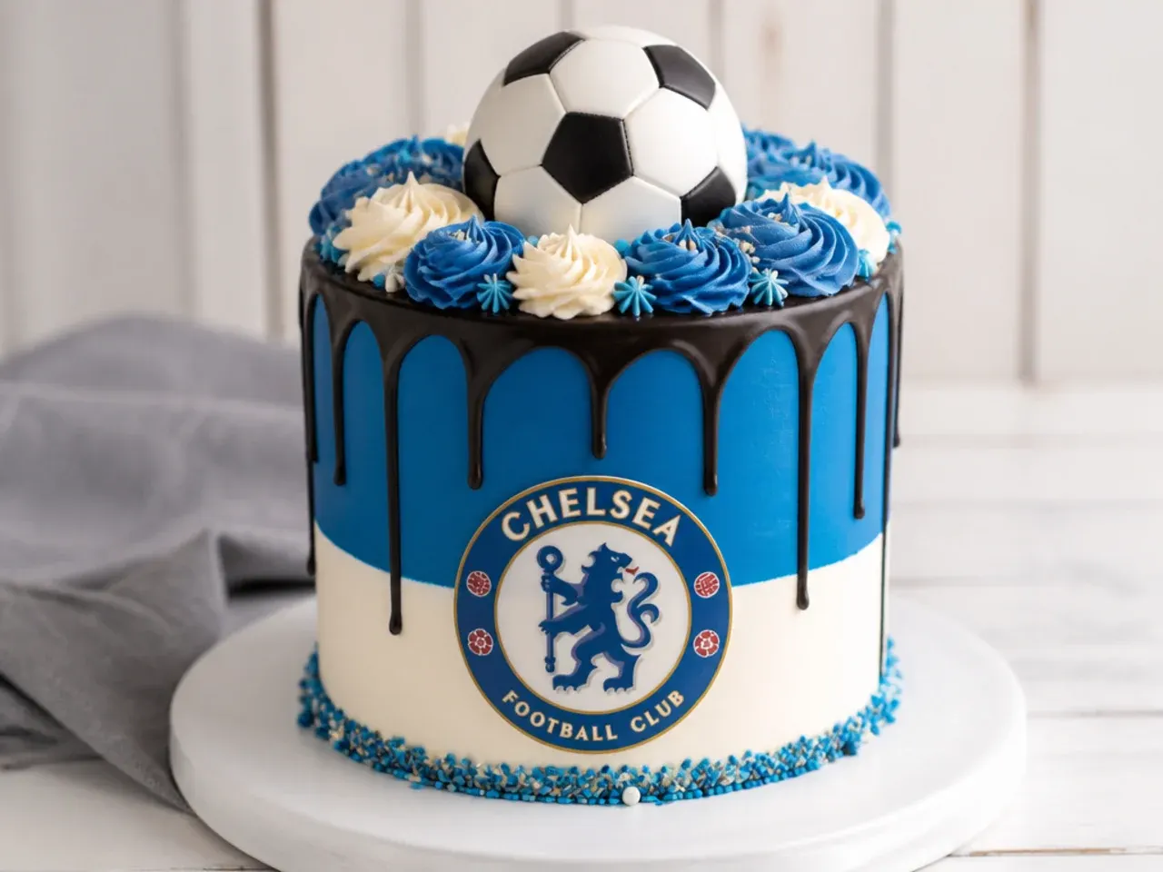 Modern team-colour football drip cake for boys topped with a chocolate ball