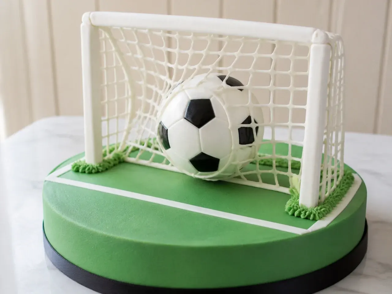 Creative football cake for boys showing a ball hitting a goal net