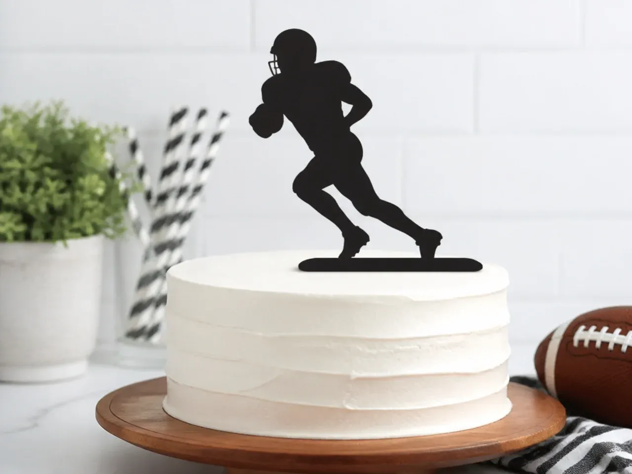 Minimal flat fondant football silhouette cake topper on white buttercream