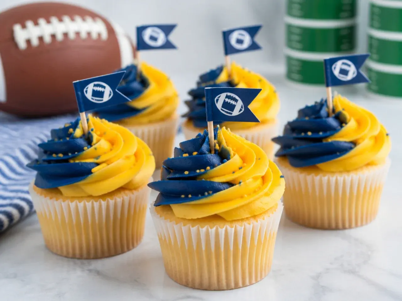 Colorful football cupcakes with two-tone team-color buttercream swirl and mini flag