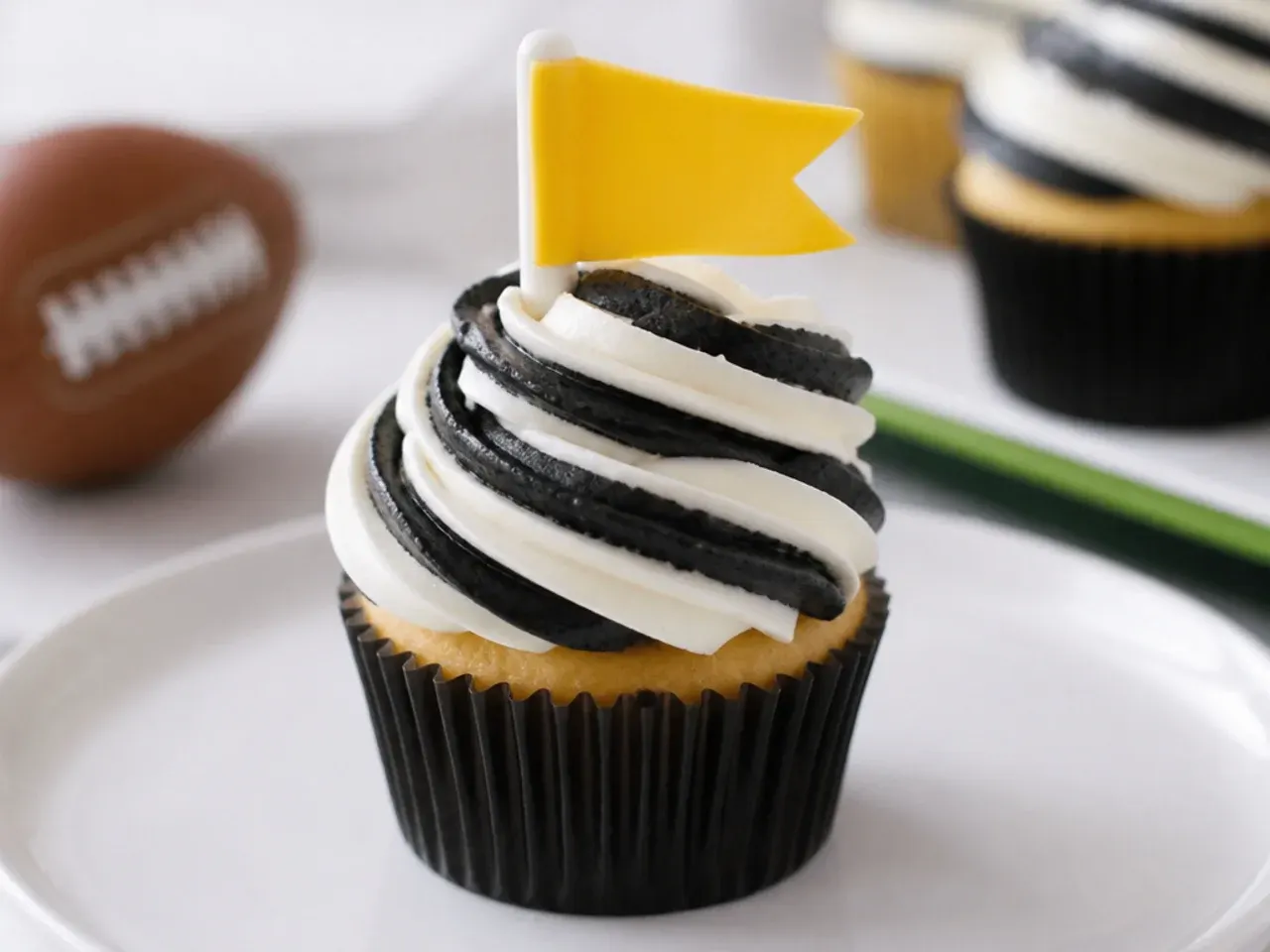 Playful referee-striped football cupcakes with black and white buttercream and a yellow flag