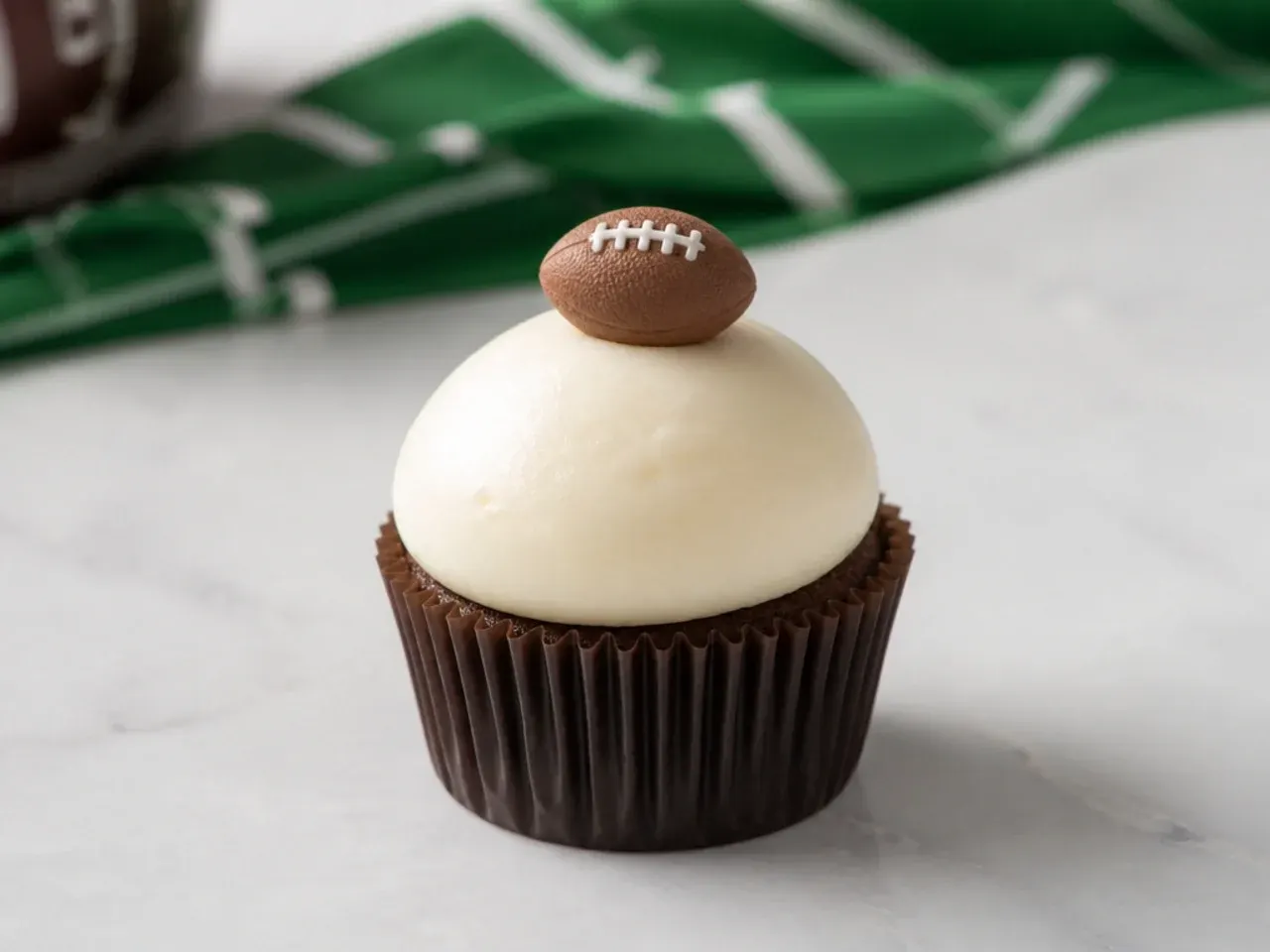 Minimal football cupcakes with a smooth cream dome and one small chocolate fondant football