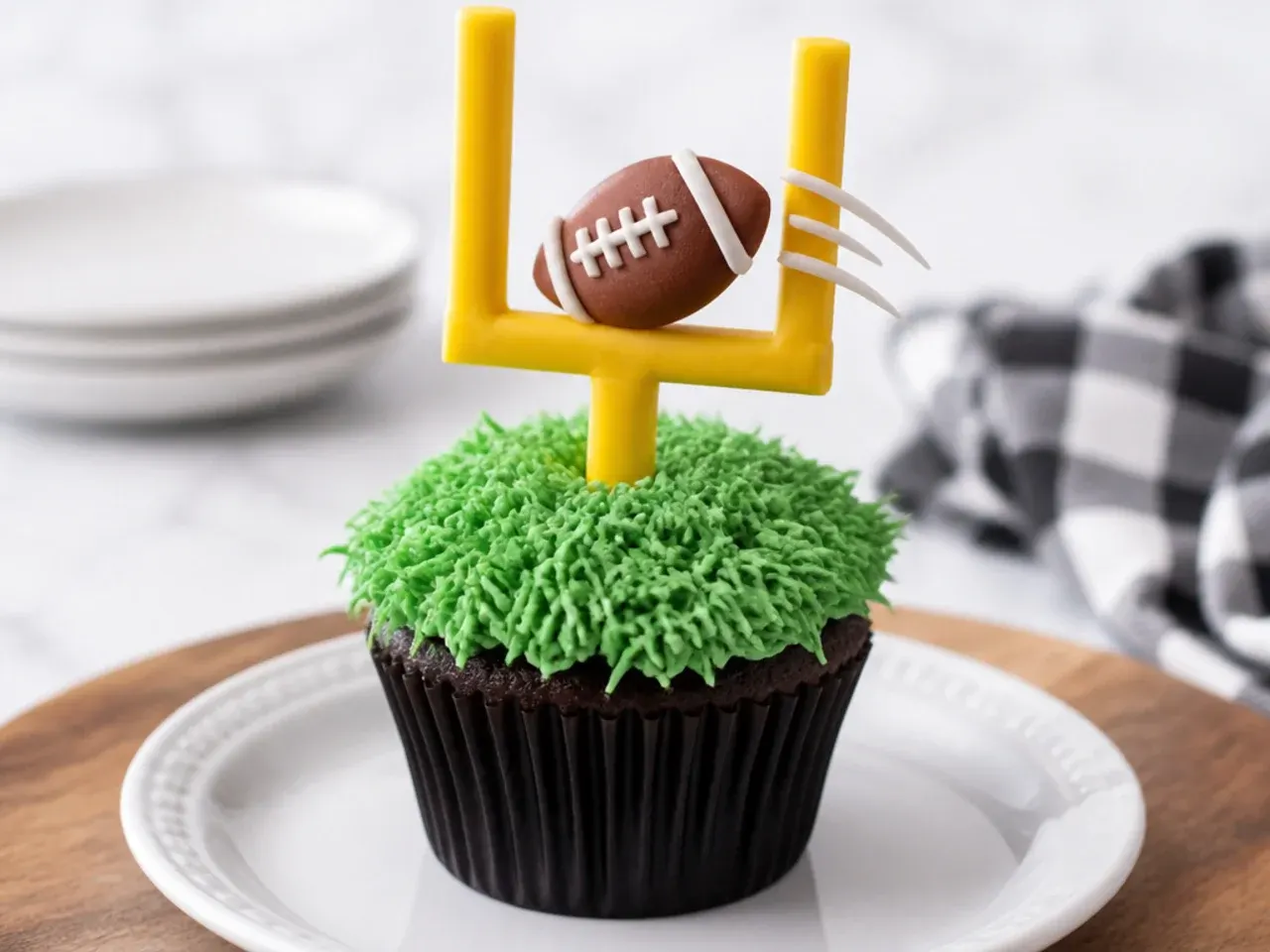 Whimsical football cupcakes with yellow fondant goalposts and a football flying through