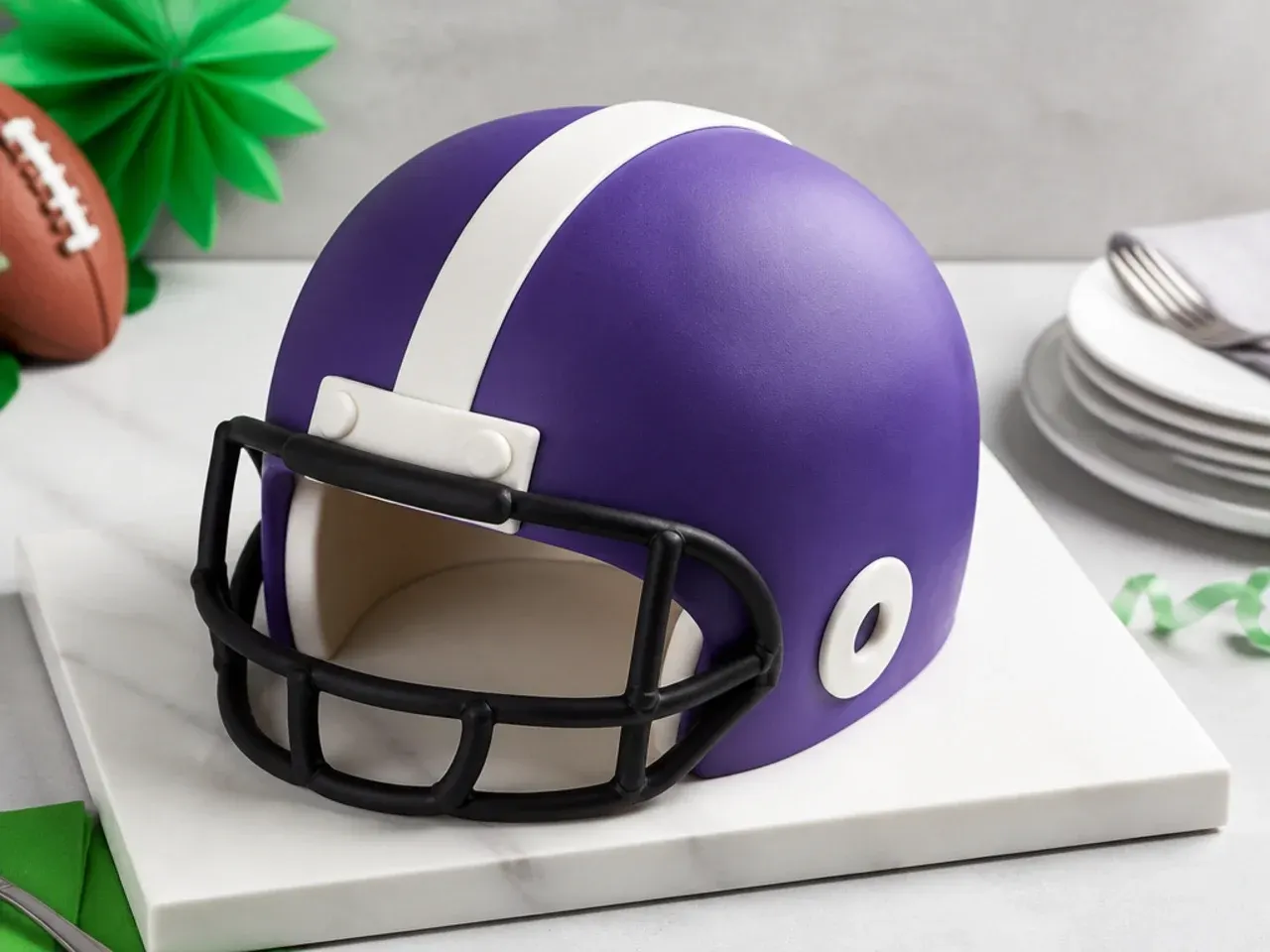Modern half-sphere football helmet cake on a minimalist slab base with one bold stripe