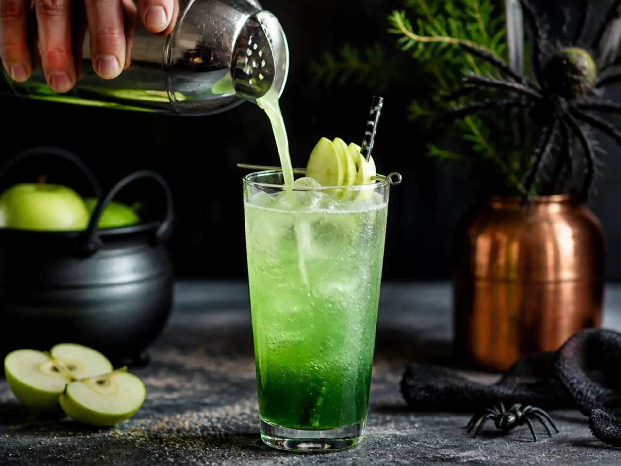 A glowing green apple spritzer in a glass with a thin apple slice on the rim.