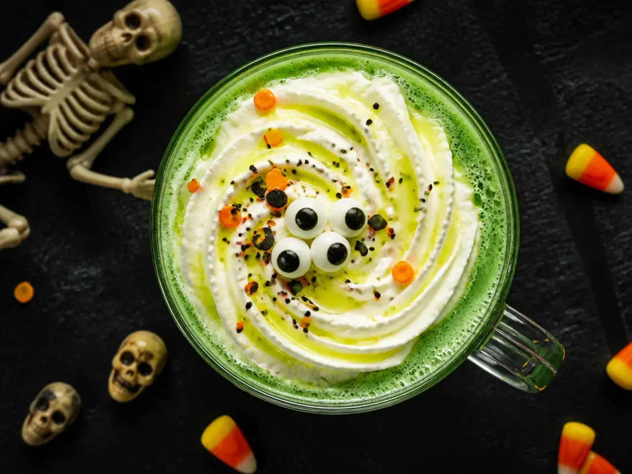Green mummy juice drink wrapped in white fruit leather bandages with candy eyes on the glass