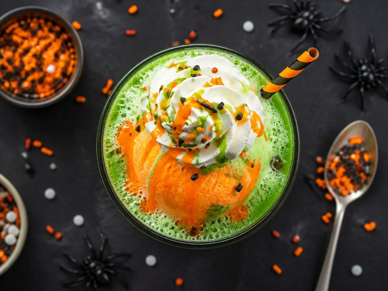 Green witches brew punch with lime sherbet foaming in a glass punch bowl for halloween drinks for kids