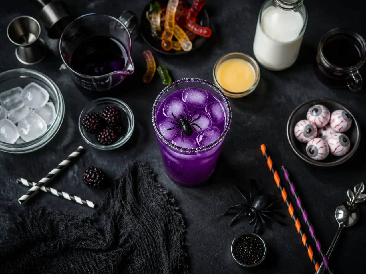 Close-up of hands adding green food colouring to a halloween drink for kids