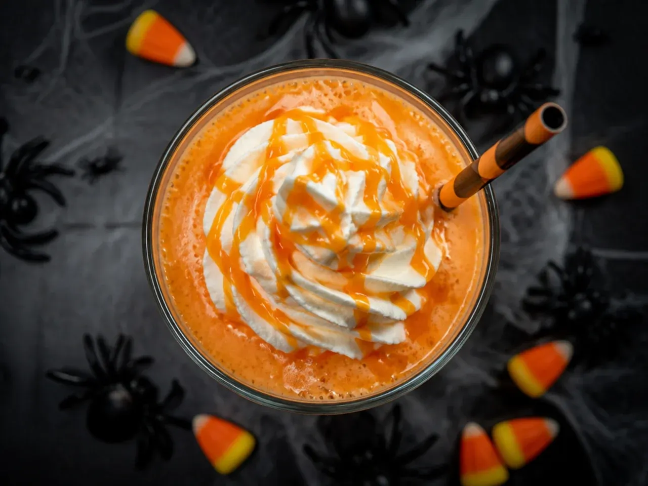 A punch bowl of orange sherbet witches brew with foamy scoops floating on top