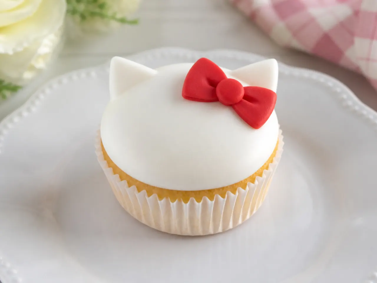 Minimal white Hello Kitty cupcakes with a single red fondant bow