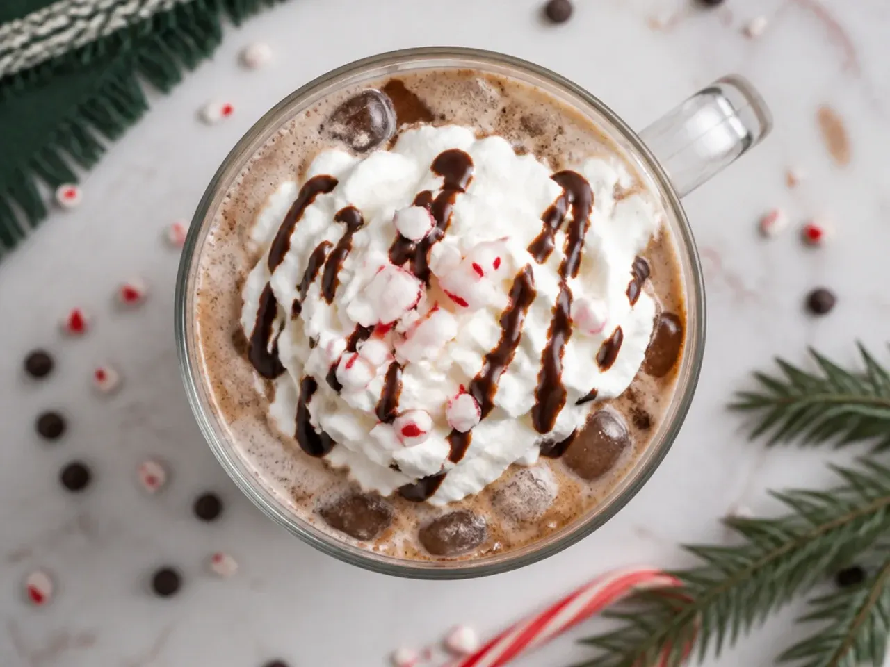 Iced peppermint mocha in a tall glass with crushed candy cane rim and whipped cream