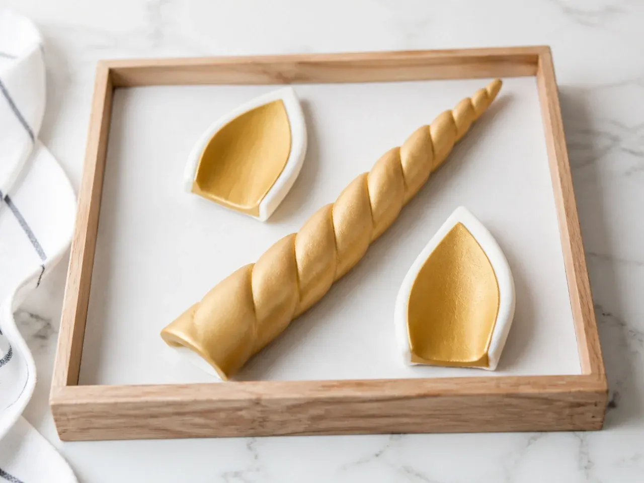 Gold fondant horn and ears drying overnight for a homemade unicorn cake