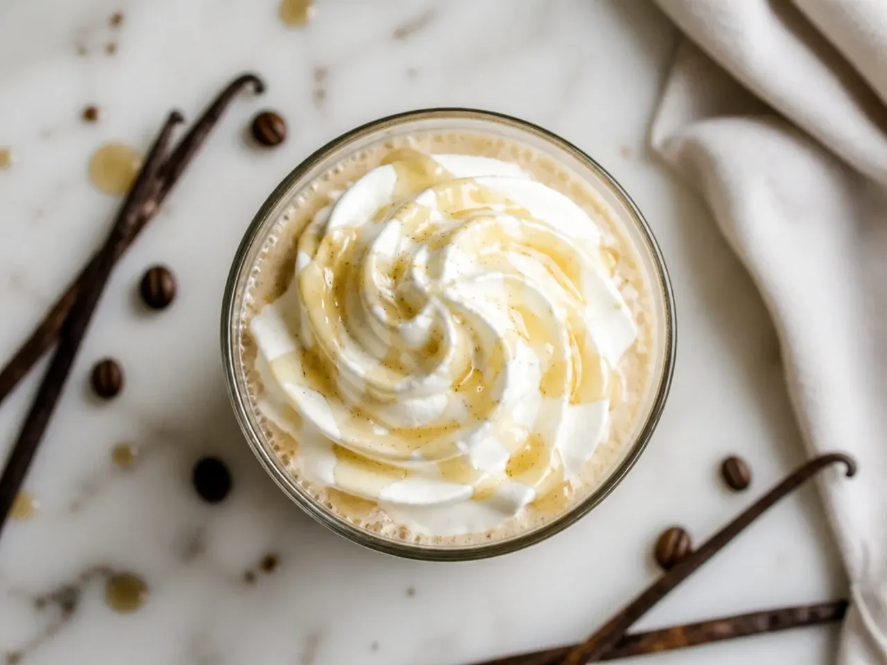 Hot vanilla bean latte with light foam in a clear glass mug