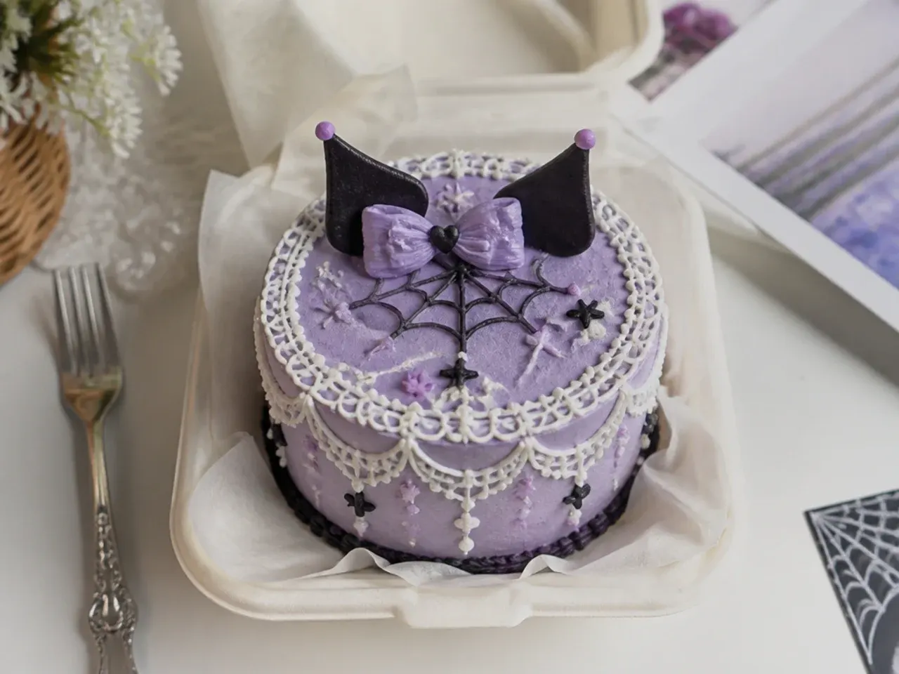 Delicate kuromi bento cake with fine white piped lace on lilac base