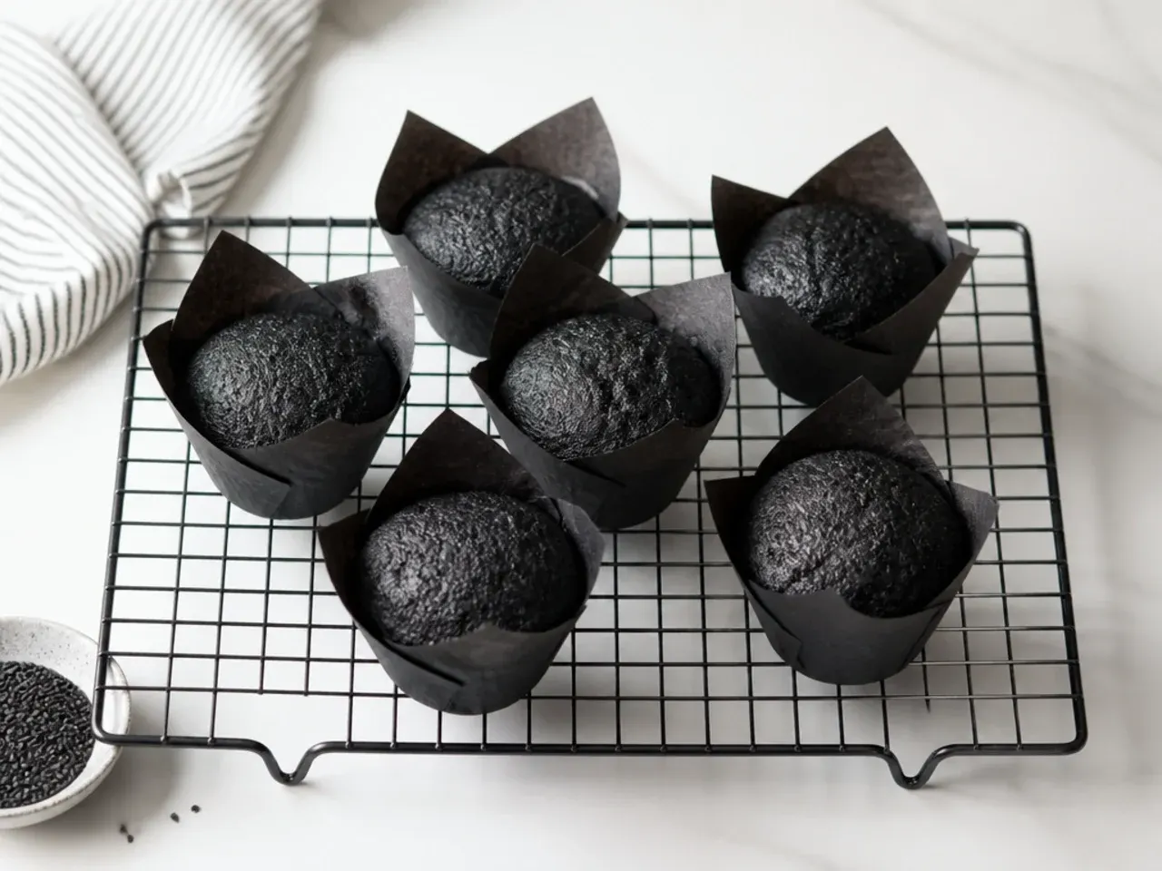 Easy one-bowl mini black cakes cooling in tulip muffin cases