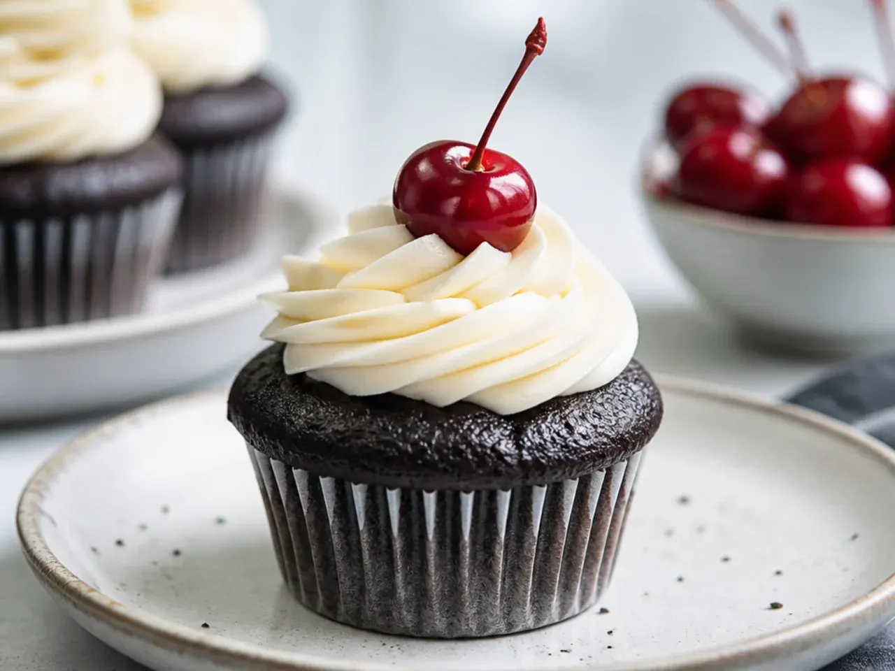 Playful moist black cake cupcakes with cream cheese swirl and cherry