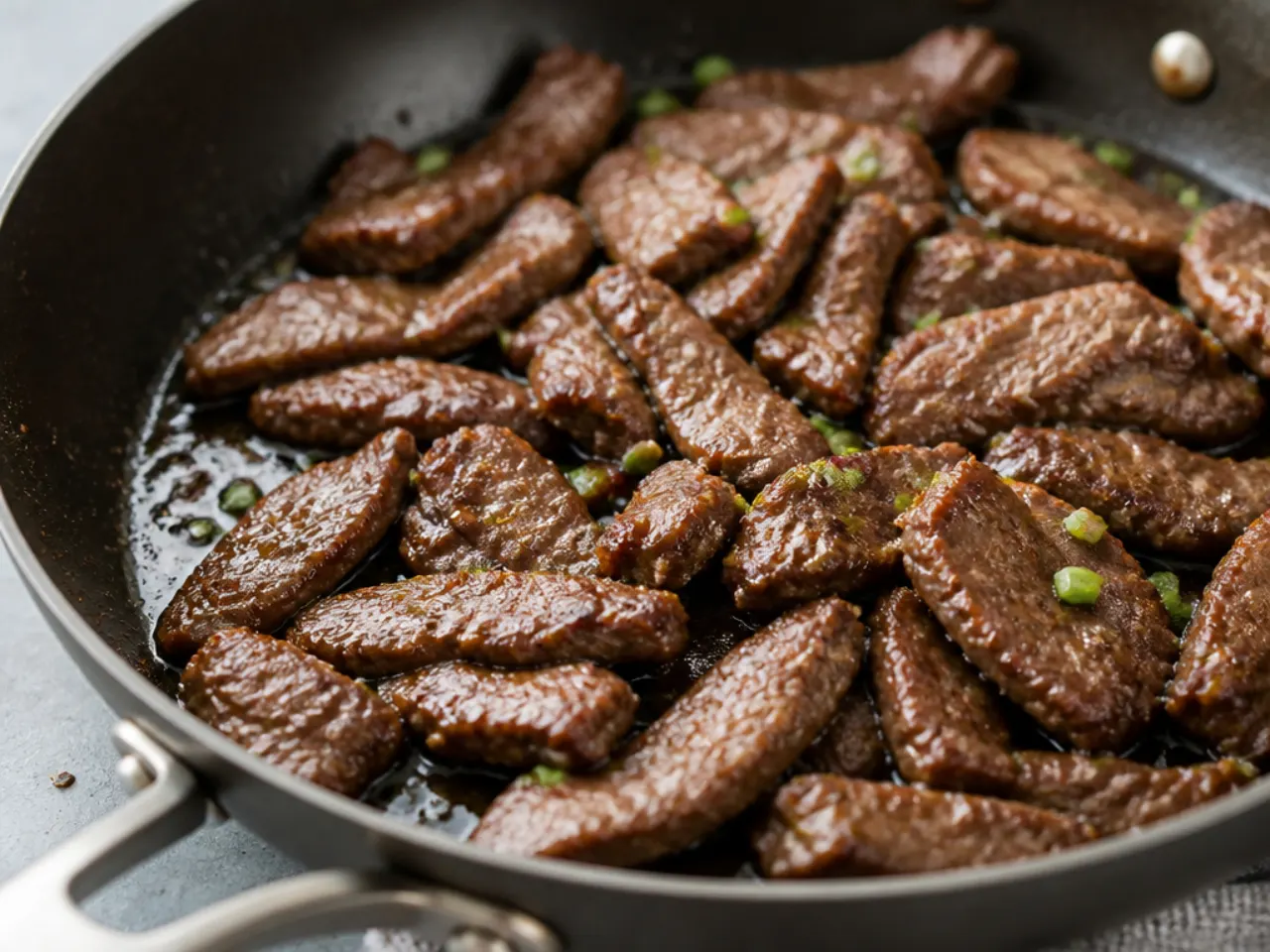 Close-up of crispy Mongolian beef strips searing in a hot pan for the base recipe