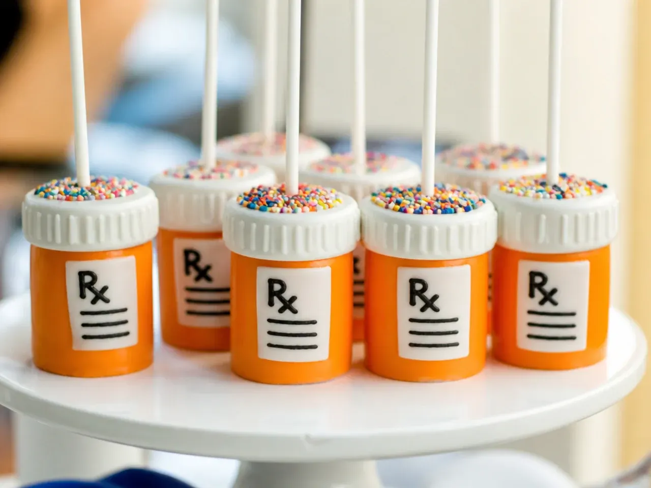 Pill bottle shaped cake pops chilling on a tray before being dipped