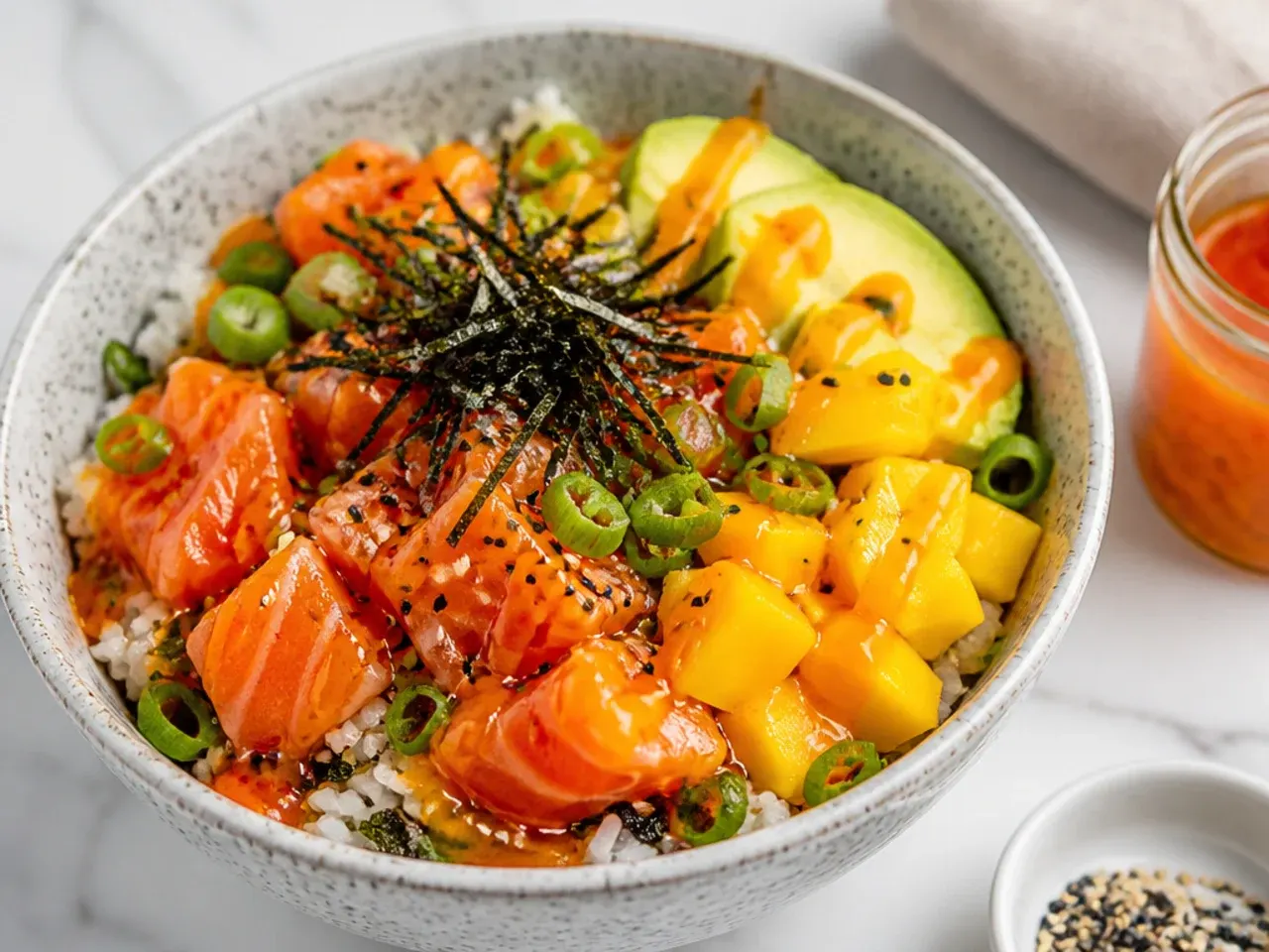 Charming mango habanero sauce drizzled over salmon sushi bowl with diced mango