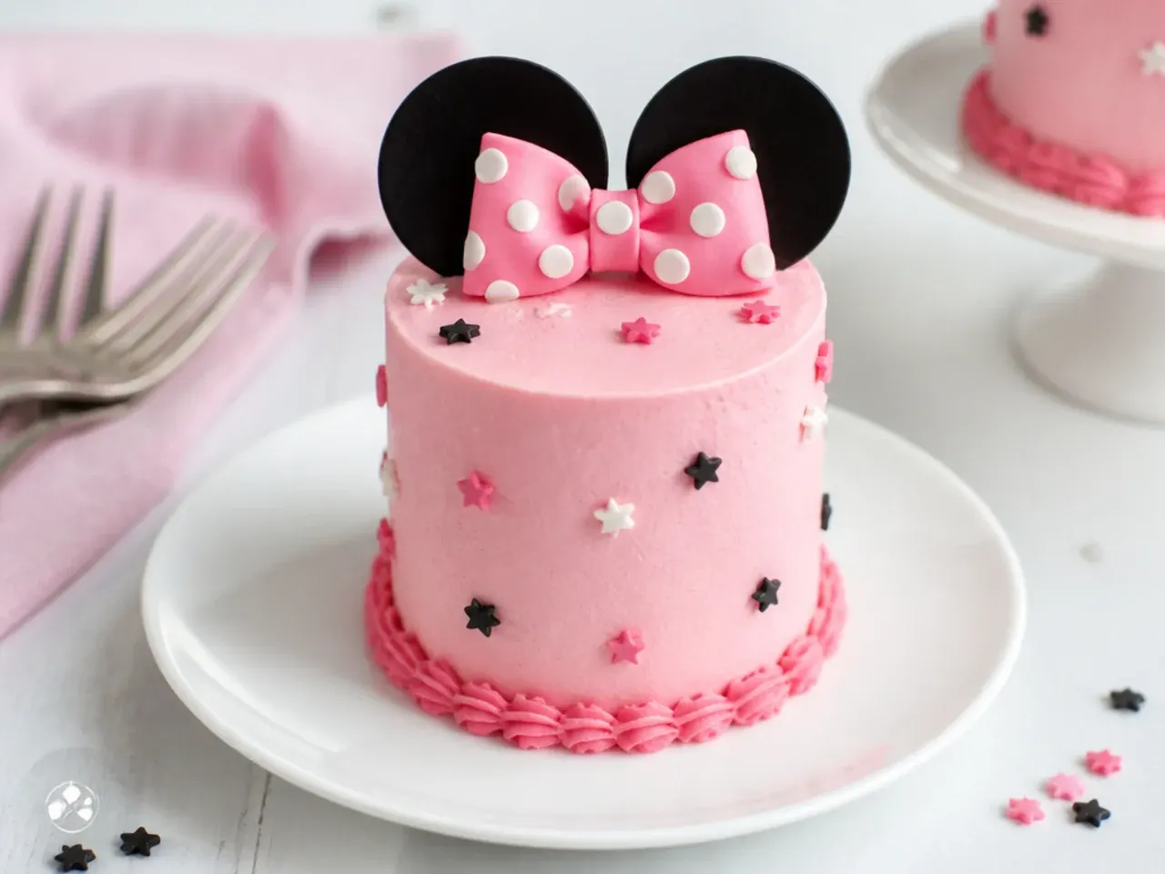 Charming individual mini simple Minnie Mouse cakes with pink frosting and tiny bows